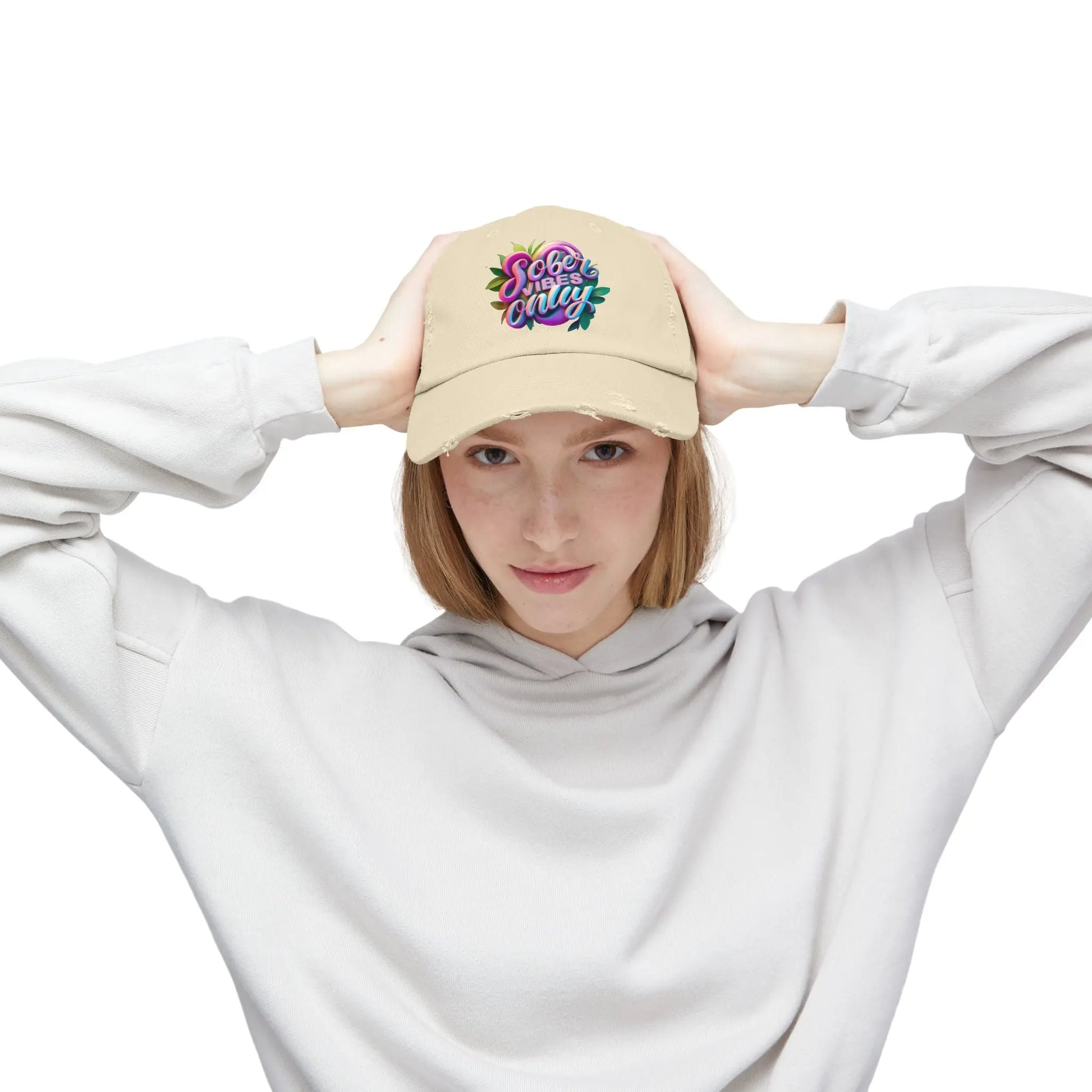 Person wearing a beige Trucker Hat with colorful design and white hoodie on a white background
