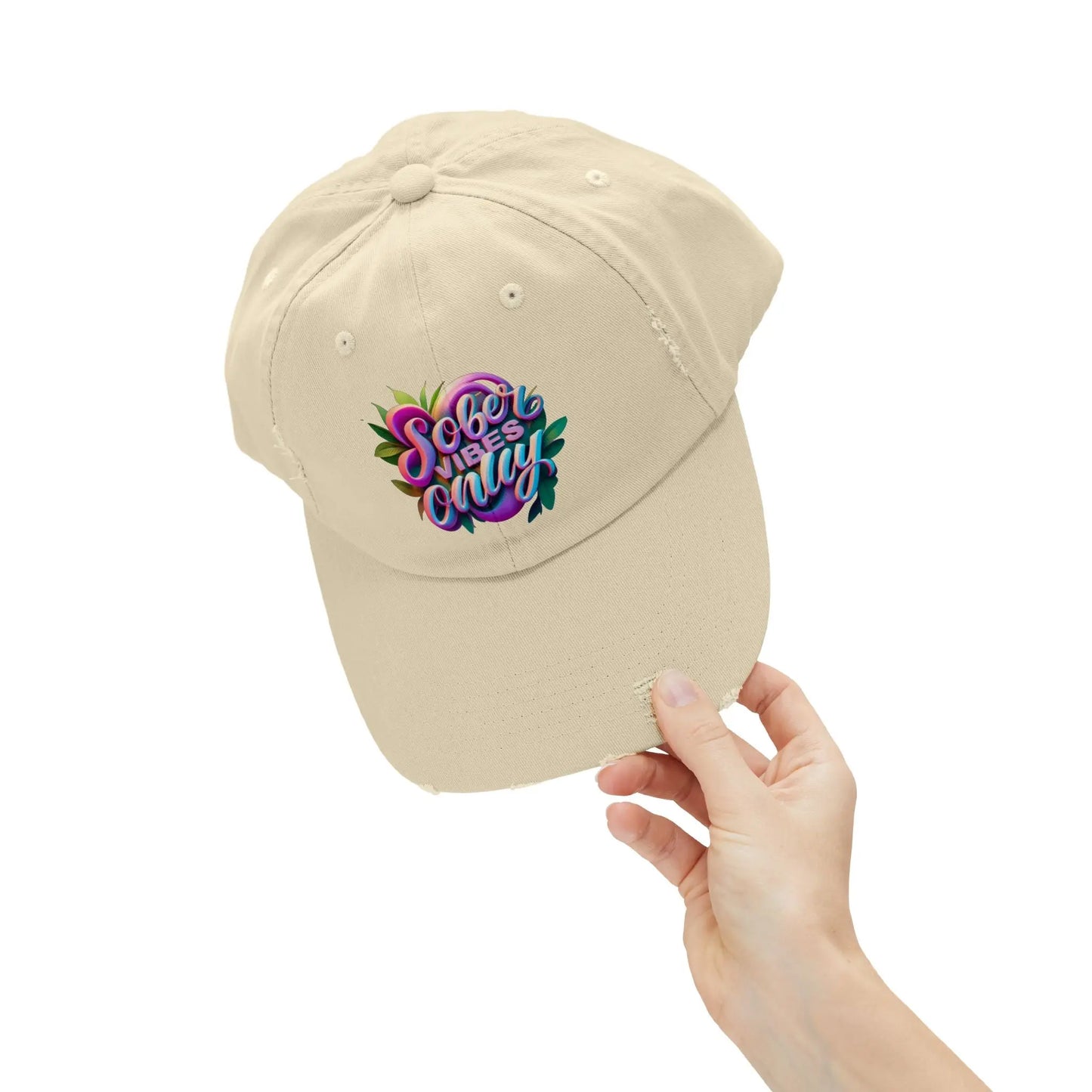 Beige Trucker Hat with colorful text held by a hand on a white background